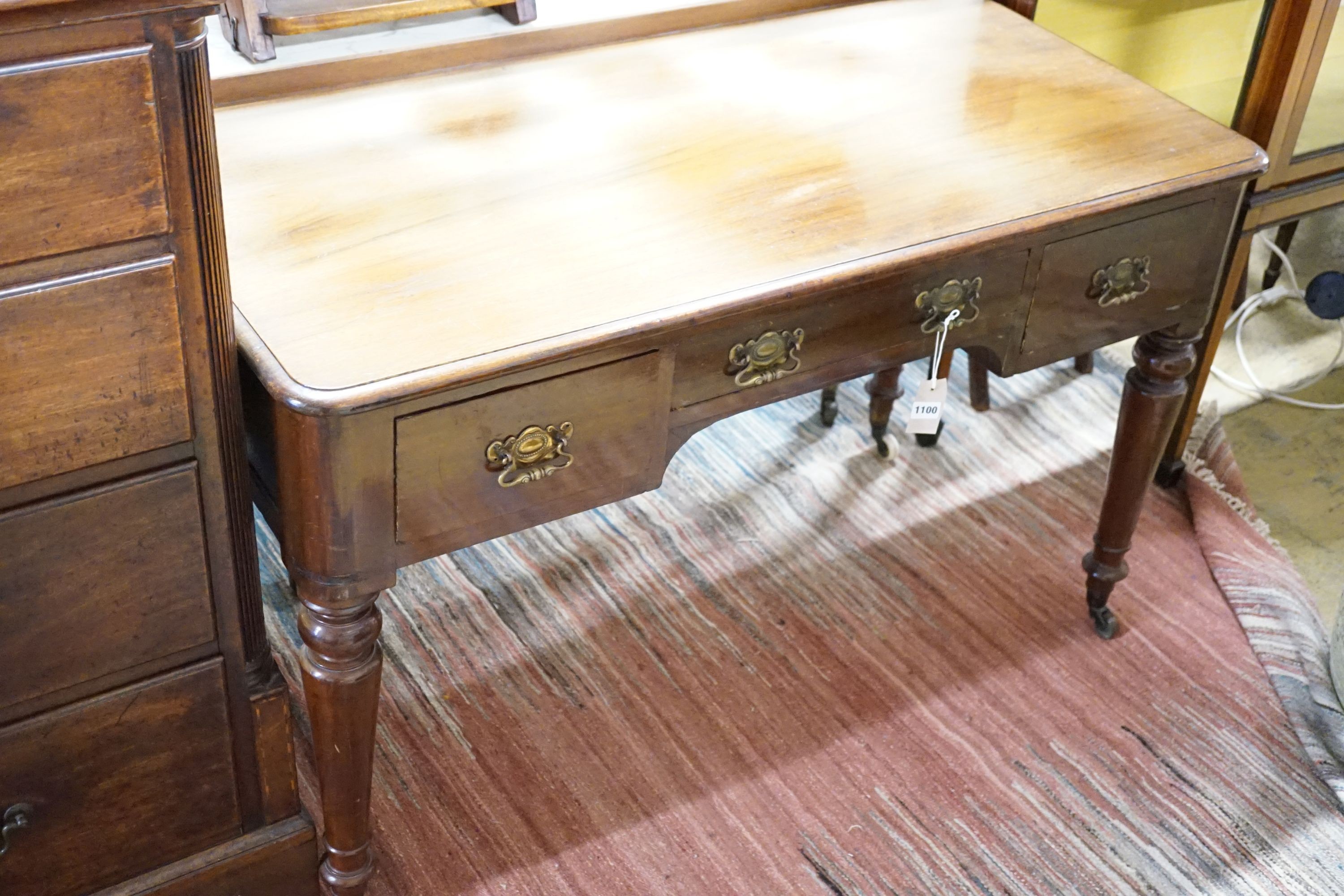 A Victorian mahogany writing table fitted three frieze drawers and turned tapering legs on castors, 121 cm wide, 59 cm deep, 77 cm high